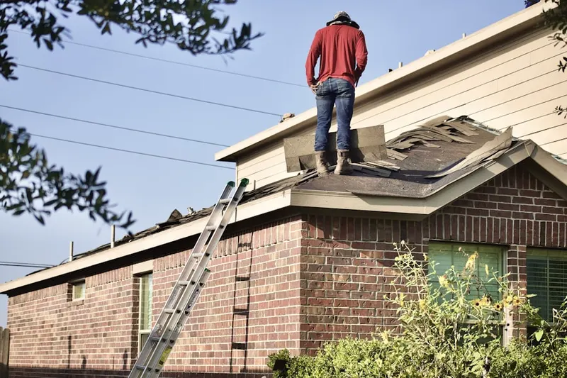 Professional roofer working on a residential roof in Brandamore